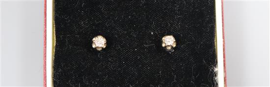 A pair of white metal and solitaire diamond ear studs.